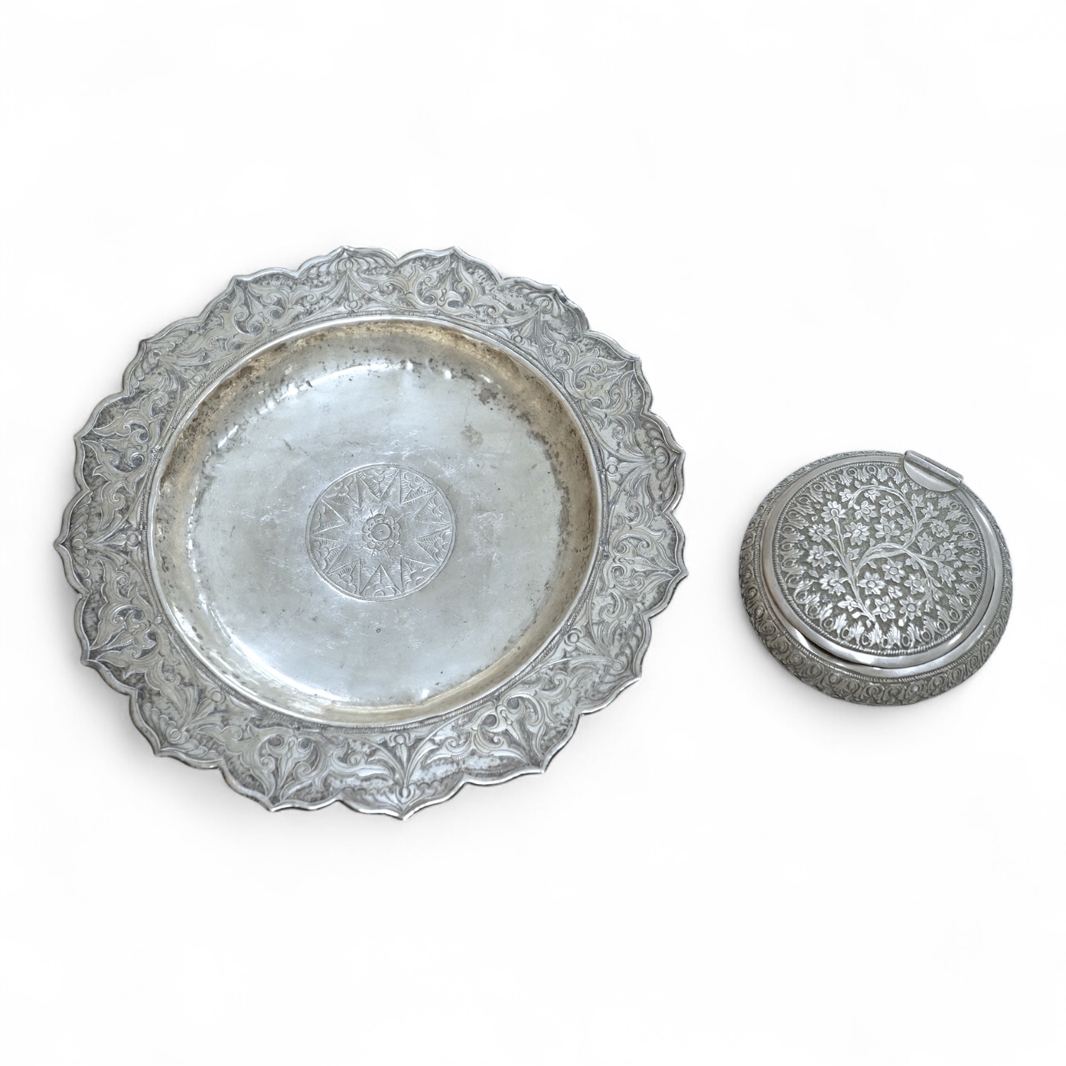 A Thai white metal tobacco box, embossed with foliage, diameter 72mm together with a similar dish.